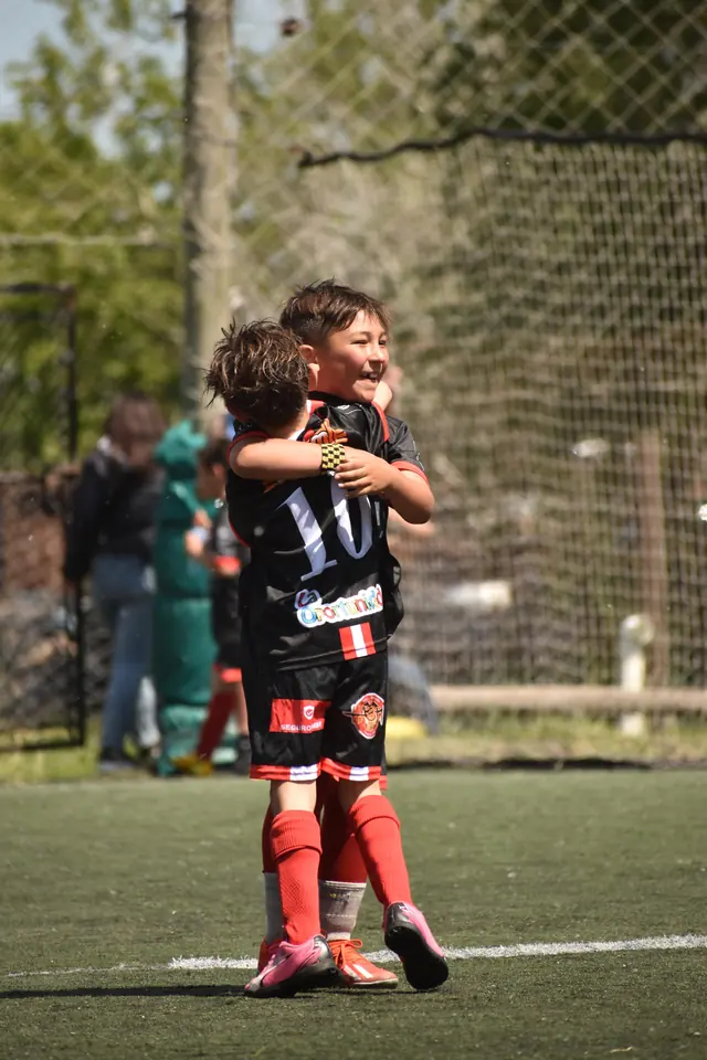 Dos jugadores infantiles abrazándose