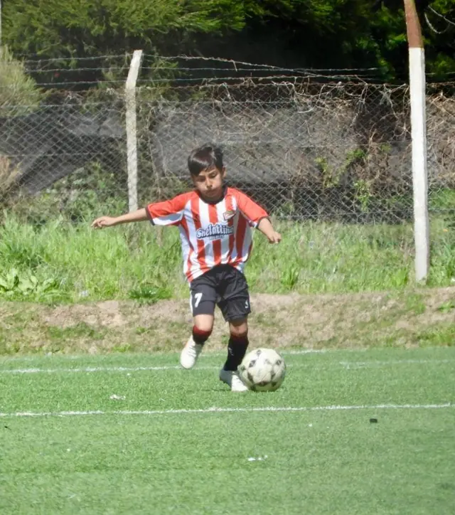 Jugador infantil llevando la pelota
